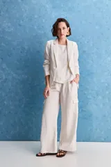 Blazer color beige claro, de corte clásico con solapa, cierre de un botón y bolsillos delanteros de vivo.