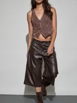 Bermuda estilo culotte confeccionada en cuerina color marrón chocolate, con diseño holgado y costuras horizontales decorativas en las piernas.