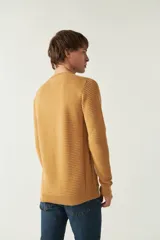 Sweater negro de punto con textura acanalada horizontal, cuello redondo y logo bordado en el pecho.