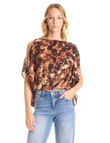 Blusa de gasa con estampado abstracto en tonos marrones y negros. Presenta cuello a la base, diseño de mangas tipo capa con aberturas laterales y silueta holgada con ruedo en punto smock.