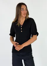 Top de punto negro con escote en V y botones frontales. Cuenta con mangas cortas abullonadas con textura calada.