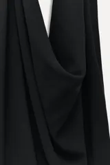 Top negro de viscosa con cuello halter drapeado, espalda descubierta y bajo asimétrico.