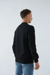 Buzo blanco de felpa con cuello redondo, mangas largas y puños. Presenta un estampado en relieve con texto y logo en goma.