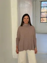 Polerón de punto color visón con cuello alto holgado, mangas largas con puños acanalados y diseño de corte amplio.