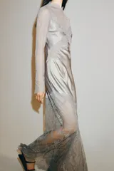 Vestido largo de satén y encaje color gris, con cuello redondo, manga larga y cierre en la espalda con abertura y botón.