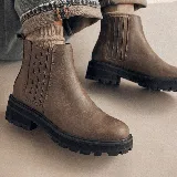 Bota tipo chelsea de cuero color marrón, con paneles laterales elásticos y suela track negra de goma con plataforma.