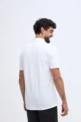 Remera polo verde militar de algodón pima, con cuello y puños acanalados, cierre frontal de tres botones y pequeño bordado de ave en el pecho.