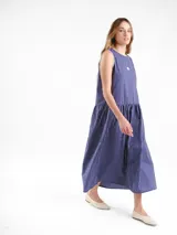 Vestido largo sin mangas, de corte amplio y relajado, con estampa a cuadros, escote redondo y falda fruncida. Cuenta con detalles de costura a contratono en las sisas y logo frontal.