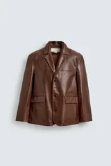 Blazer de corte relajado confeccionada en piel napada, con cuello de solapas de muesca, manga larga y cierre frontal de tres botones. Presenta bolsillos con solapa en la parte delantera.