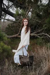 Bolso tipo tote de cuero con acabado envejecido en tonos oscuros. Presenta doble asa de hombro con detalle de tachas metálicas y nudos decorativos en la unión con el cuerpo del bolso. Cuenta con un diseño amplio y estructurado.