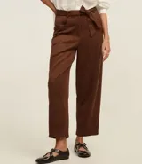 Pantalón de gamuza color marrón chocolate, de corte recto y tiro alto, con cinturón de tela a tono.