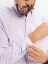 Camisa de manga larga marca Cuatro Ases, confeccionada en algodón con diseño de microcuadros en tono azul claro. Presenta cuello clásico con botones, cierre frontal abotonado y bolsillo en el pecho.