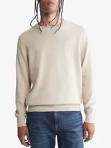 Sweater de algodón color beige, de cuello redondo y corte clásico. Presenta el logo de la marca bordado en el pecho.