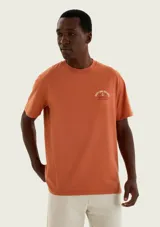 Remera de corte regular y manga corta en color naranja, con pequeño estampado tipográfico y gráfico de ancla en el pecho.