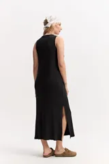 Vestido largo de morley color marrón, con escote redondo, silueta al cuerpo y aberturas laterales en el ruedo.
