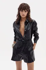 Camisa negra de lino metalizado con cuello camisero clásico, mangas largas y ruedo curvo más largo atrás.