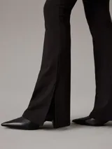 Leggings negros de punto milano con talle alto, corte slim, pierna acampanada y bajo abierto. Confeccionados con un 66% de viscosa, 30% de nailon y 4% de elastano.