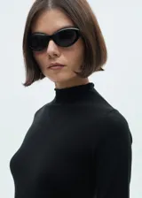 Vestido midi de punto fino con cuello alto, manga larga y diseño recto. Presenta una abertura lateral en el bajo.