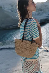 Bolso tipo shopper formato mini confeccionado en yute trenzado, con doble asa de mano en cuero sintético color marrón.