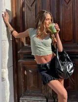 Remera corta color verde agua, con escote en V y detalle de puntilla blanca en el borde.