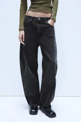 Jeans de tiro medio con diseño baggy barrel, confeccionados en denim color beige con efecto lavado. Presentan cinco bolsillos, costuras laterales torcidas y cierre frontal con cremallera y botón metálico.