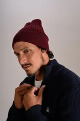 Gorro de lana tejido en punto rib, color bordó, con diseño de doblez en el borde y etiqueta pequeña lateral.