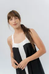 Vestido midi negro con panel frontal blanco, de corte amplio, escote recto y tiras anchas.