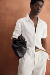 Camisa azul de corte regular fit confeccionada en tejido de lino y algodón, con cuello abotonado, manga larga, bolsillo aplicado en el pecho y cierre frontal con botones.