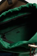 Mochila multibolsillos de diseño colorblock en tonos verde, azul marino, marrón y violeta, con solapa frontal y cierre de hebilla ajustable.