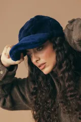 Gorro con visera de corderito color azul marino, de textura suave y abrigada.