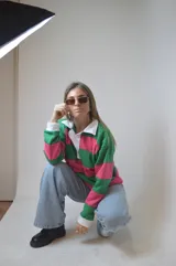 Sweater a rayas horizontales rosas y verdes, con cuello polo blanco y puños blancos.