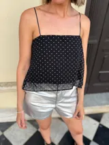 Top de gasa color negro con estampado de lunares blancos, de corte suelto con breteles finos y espalda abierta regulable.