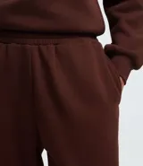 Pantalón jogger de corte holgado confeccionado en tejido fleece color beige, con cintura elástica y puños ajustados en el bajo. Cuenta con bolsillos laterales.