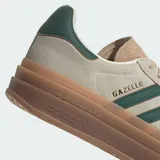 Championes Adidas Gazelle Bold color beige con las tres tiras clásicas en verde oscuro y suela de goma marrón con plataforma.