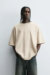 Camiseta color caqui de corte holgado, con cuello redondo y mangas cortas. Acabado con efecto lavado y ruedo irregular.