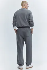 Pantalón deportivo de felpa con interior cepillado, corte relajado, cintura elástica con cordón de ajuste, bolsillos laterales y puños acanalados en los tobillos.