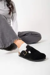 Mocasines negros de cuero con hebilla dorada y suela de corcho.