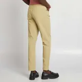 Pantalón chino de corte slim fit, color beige, con cinco bolsillos y cierre de botón y cremallera.