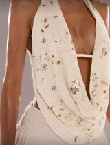 Top halter color crema con escote drapeado y apliques de lentejuelas doradas.