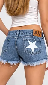 Short de jean tiro bajo con diseño de estrella blanca estampada en el bolsillo trasero y terminaciones desfleCADas.