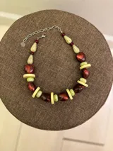 Collar corto de cuentas de resina en tonos marrón rojizo, verde claro y beige, con diseño de esferas y discos intercalados.