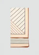 Fular cuadrado de lana con estampado geométrico en tonos beige, marrón y negro, con bordes definidos.