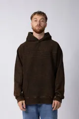 Buzo canguro de frisa gruesa con capucha, diseño oversize y acabado con efecto gastado. Presenta recortes horizontales en el frente y puños con elástico.