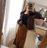 Falda larga de gamuza color marrón óxido, con cuatro tajos y corte acampanado.