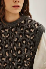 Chaleco de punto con diseño de animal print de leopardo en tonos grises y negros, con cuello redondo y corte sin mangas.