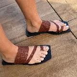 Sandalias chatas negras de cuero vacuno, con base cuadrada y tiras anchas sobre el empeine y el dedo gordo.