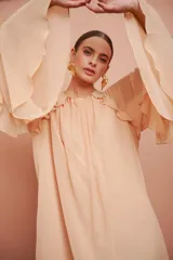 Vestido corto color salmón claro, de mangas largas con volados y corte suelto.