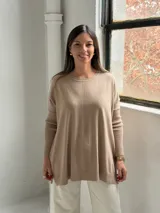 Sweater de punto color visón con cuello redondo, mangas largas con puños acanalados y diseño holgado con detalle de costura vertical central.