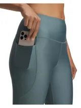 Calza deportiva Under Armour de tiro alto, confeccionada en tejido HeatGear ultraligero y elástico. Presenta diseño con costuras ergonómicas, cintura antideslizante y bolsillo lateral integrado.