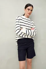 Bermuda de tiro medio color azul oscuro, con silueta recta y largo a la altura de la rodilla. Presenta bolsillos laterales y traseros, y costuras visibles que aportan un toque casual.